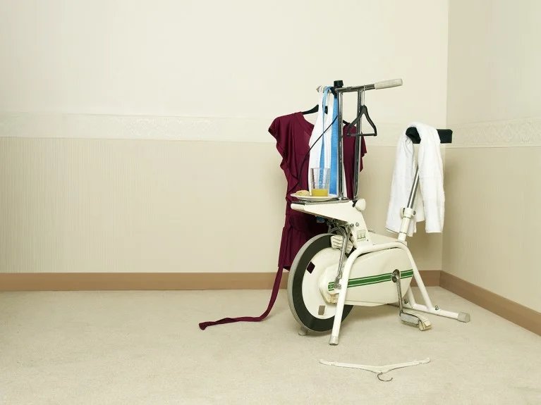 An exercise bike with clothes hanging on it